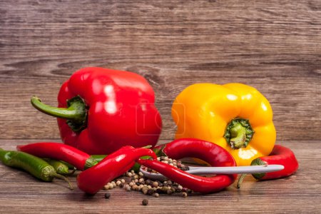 Photo for Raw food. Spicy and sweet pepper in studio photo on wooden background - Royalty Free Image
