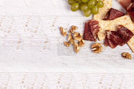 Téléchargez les photos : Jambon italien avec craquelins et raisin sur fond de bois - en image libre de droit