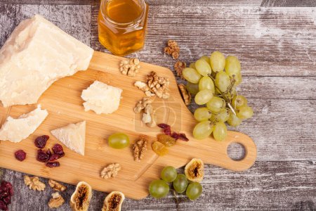 Photo for Healthy food. Grape, nuts, honey and cheese on wooden background - Royalty Free Image