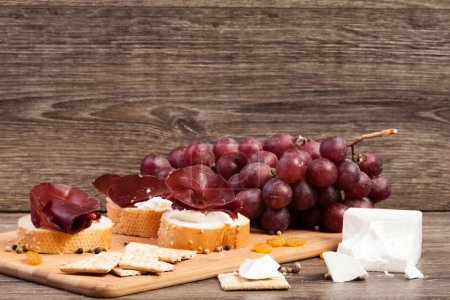 Téléchargez les photos : Jambon, fromage blanc et raisin sur fond bois. Aliments sains - en image libre de droit