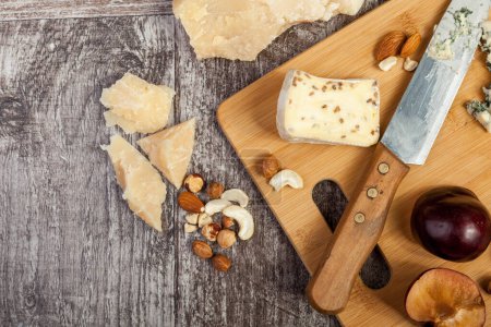 Téléchargez les photos : Sur le dessus de la plaque de bois avec différents tupe de fromage sur fond de bois vintage - en image libre de droit