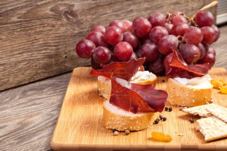 Téléchargez les photos : Jambon, fromage blanc et raisin sur fond bois en studio photo - en image libre de droit