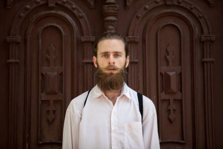 Photo for Portrait of bearded hipster in front of a door. Style and diversity - Royalty Free Image