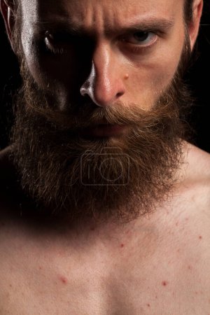 Photo for Portrait of tattooed bearded hipster on black background in studio photo. Expression and fashion - Royalty Free Image