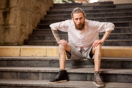 Photo for Tattoed and bearded hipster guy posing outdoor in the city - Royalty Free Image