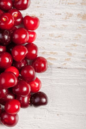 Photo for Fresh cherries on white wooden table. Raw healthy fruits - Royalty Free Image