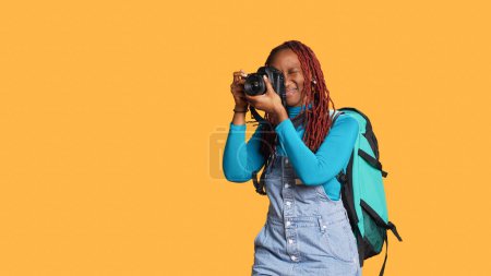 Photo for Happy girl using dslr camera for images, taking photos with lens and equipment going on vacation trip. Female photographer sightseeing and making memories, citybreak adventure. - Royalty Free Image