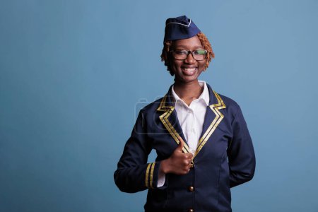 Photo for African American woman giving ok sign in front of camera, expressing positivity and satisfaction. Optimistic female flight attendant giving the ok sign to an excellent idea. - Royalty Free Image