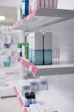 Photo for Selective focus of drugstore shelves filled with vitamins and pharmaceutical products to sell prescription medicine or treatment to customers. Empty pharmacy with medication and pills bottles. - Royalty Free Image