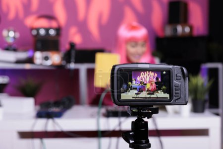 Téléchargez les photos : Vlogger asiatique montrant ordinateur portable à la caméra tout en enregistrant examen des fournitures scolaires parler avec les abonnés pendant podcast. Créateur de contenu filmant vlog en utilisant un équipement de streaming professionnel - en image libre de droit