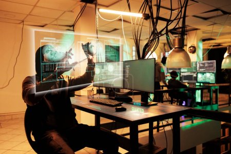 Afroamerikanische Hacker durchbrechen Datenbank mit Hologrammen und KI, verwenden futuristisches Display vor ihm, tragen Virtual-Reality-Headset