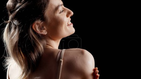 Photo for Happy positive girl using cream to moisturize skin, applying moisturizer on body and enjoying beauty skincare routine. Flawless glowing woman promoting bodycare and self confidence. - Royalty Free Image