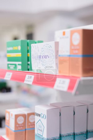 Photo for Selective focus of pharmacy shelves full with spf products and pharmaceuticals drugs boxes to sell prescription medicine or treatment to clients. Empty health care store filled with vitamins and pills - Royalty Free Image