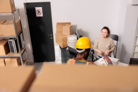 Photo for Diverse storehouse team discussing goods packaging details before start working at customers orders in warehouse. Stockroom employees planning merchandise inventory, analyzing products checklist - Royalty Free Image