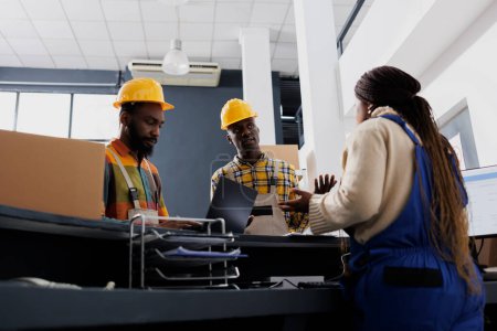 Photo for Post office manager explaining loaders order picking instruction at warehouse reception counter desk. All black storehouse workers team discussing freight dispatching management - Royalty Free Image