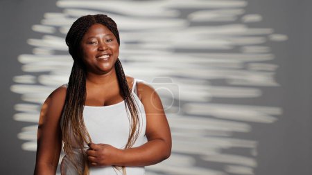 Photo for Female model embracing imperfections in studio, posing for empowering wellness ad campaign. Sensual gentle woman with luminous glowing skin feeling confident with body and skintone. - Royalty Free Image