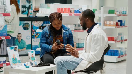 Photo for Pharmacy worker recommending medication to woman, talking about prescription medicine with vitamins and pills. Doctor explaining disease treatment and supplements in drugstore. Tripod shot. - Royalty Free Image