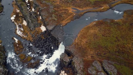 Foto de Drone disparo de cascada de hielo nórdico, flujo de agua masiva que fluye por los acantilados formando hermosa cascada de oxarafoss. Naturaleza islandesa y río frío. Movimiento lento. - Imagen libre de derechos