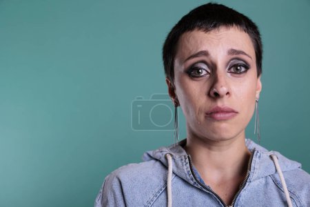 Foto de Retrato de una mujer caucásica deprimida e infeliz mirando a la cámara mientras lloraba en un estudio con un fondo aislado, una persona con un colapso mental. Mujer preocupada con expresión de dolor - Imagen libre de derechos