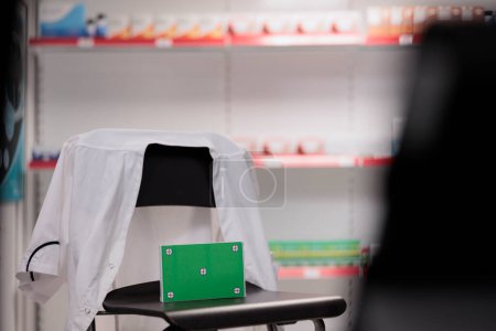 Téléchargez les photos : Écran vert maquette chroma paquets de vitamines clés debout sur la chaise dans un établissement de soins de santé, prêt pour les clients à venir acheter un traitement médical. Pharmacie remplie de produits pharmaceutiques - en image libre de droit