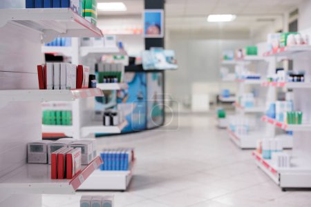 Photo for Empty drugstore with nobody in it with containers and boxes full with medicaments, retail shop shelves with pharmaceutical products. Pharmacy space filled with medical drugs and vitamins boxes. - Royalty Free Image