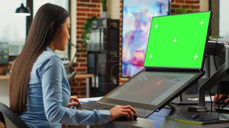 Photo for Female office worker using game developing interface and greenscreen display on monitors. Artistic editor working with blank chroma key template on isolated copyspace, planning 3d project. - Royalty Free Image