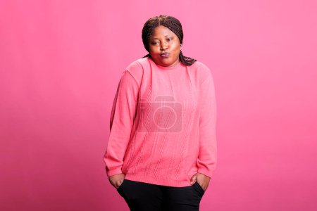 Photo for Portrait of doubtful woman shrugging shoulders having questioning facial expression, standing over pink background. Thoughtful adult standing with hands spread wide, pensive person looking at camera - Royalty Free Image