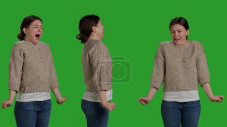 Photo for Close up of young adult acting tired and sleepy on camera, feeling exhausted in studio. Caucasian woman yawning and falling asleep over full body greenscreen backdrop, fatigued frustrated model. - Royalty Free Image