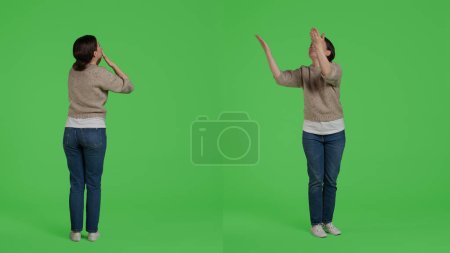 Photo for Positive optimistic girl blowing air kisses and acting lovely, being confident and joyful in studio. Young person spreading love and beautiful feelings on full body greenscreen backdrop. - Royalty Free Image
