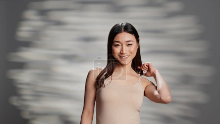 Photo for Gentle luminous girl feeling natural and empowering filming new beauty ad, using cosmetics and skincare products. Happy glowing person promoting self confidence and tenderness. - Royalty Free Image