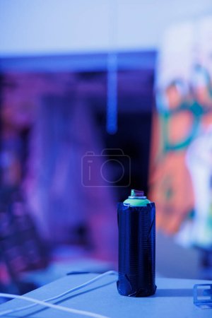 Photo for Aerosols cans used for graffiti artwork on rusty walls, spray paint containers in demolished space with blue neon lights. Abandoned empty building with fluorescent bright glow. Close up. - Royalty Free Image