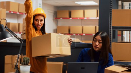 Photo for Team of people planning supply chain distribution in storage room, checking products packed in boxes. Man and women doing quality control for merchandise stock, warehouse production. Handheld shot. - Royalty Free Image