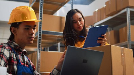 Photo for Young person planning distribution of orders in depot, working with woman to send retail store packages for supply chain. Team of employees checking merchandise and products, business development. - Royalty Free Image