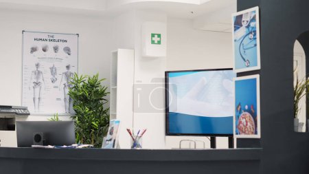 Photo for Empty registration counter in facility, hospital reception front desk filled with checkup forms and clinical reports. Waiting area lobby with health care leaflets for medical insurance service. - Royalty Free Image