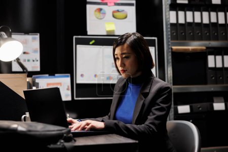 Photo for Professional asian accountant checking administrative analytical data in cabinet room office surrounded by accountancy statistic reports. Businesswoman in file storage room - Royalty Free Image