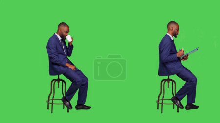 Photo for Male employee drinking coffee and taking notes, writing information on papers and enjoying hot cup of caffeine drink. Businessman thinking about new ideas to write, serving beverage. - Royalty Free Image