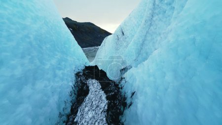 Téléchargez les photos : Vue aérienne de la crevasse du glacier vatnajokull, blocs de glace fissurés glaciaires près d'un lac gelé dans un paysage givré. Belles grottes d'icebergs en iceland. Ferme là. Mouvement lent. - en image libre de droit