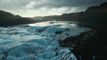 Photo for Drone shot of ice mass on frozen water, huge icy blocks floating on lake in iceland. Beautiful blue arctic landscapes and scenery with vatnajokull glacier cap, panoramic view. Slow motion. - Royalty Free Image