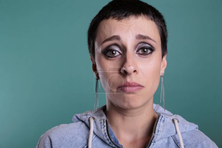 Photo for Upset unhappy woman crying after hearing of tragedy during studio shot standing on isolated background. Worried displeased adult person in tears having sadness emotion, mental breakdown - Royalty Free Image