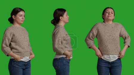 Téléchargez les photos : Close up of woman posing over greenscreen background, standing on green screen isolated template. Female model looking natural and confident, acting optimistic and smiling on camera. - en image libre de droit