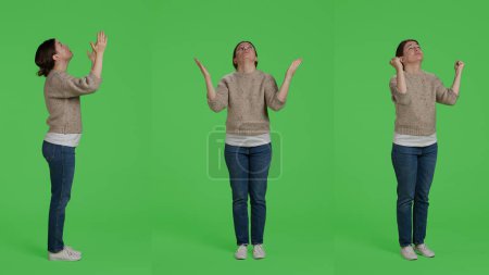 Photo for Young adult doing prayer hands symbol on full body green screen background, praying and begging to god. Religious spiritual woman hoping to receive luck or fortune, pray in silence. - Royalty Free Image