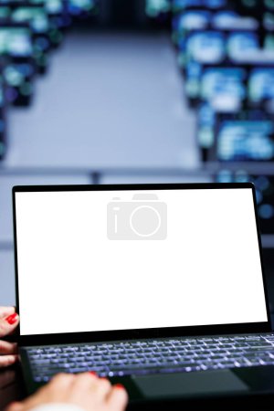 Téléchargez les photos : Gros plan sur un ordinateur portable simulé utilisé par un développeur informatique expérimenté dans un centre de données en utilisant des racks de serveur pour fournir une puissance de calcul massive, contrôler les ressources réseau, traiter et stocker des ensembles de données - en image libre de droit