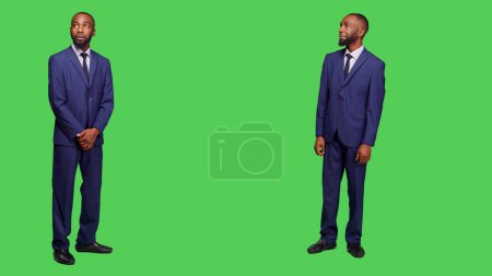 Photo for Male entrepreneur having amazed and surprised reaction, feeling stylish in business office suit over full body greenscreen. Corporate employee in awe seeing something in studio. - Royalty Free Image