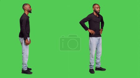 Téléchargez les photos : Un Afro-Américain impatient d'attendre en studio, pensant à quelque chose devant la caméra. Homme personne idées de remue-méninges avec patience, debout sur l'écran vert du corps entier. - en image libre de droit