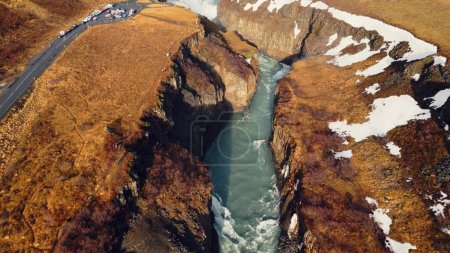 Foto de Vista aérea de la cascada del río Gullfoss, hermosa agua fría que fluye entre colinas nevadas congeladas y campos. Naturaleza islandesa y paisajes nórdicos cerca de la cascada. Movimiento lento. - Imagen libre de derechos