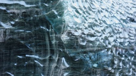 Téléchargez les photos : Blue ice mass in vatnajokull crevasse, majestic transparent ice glacier in iceland. À l'intérieur des grottes de glace avec des blocs de glace fissurés couverts de roches gelées, paysages nordiques. Coup de main. - en image libre de droit