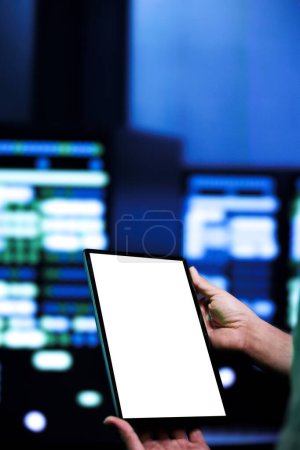Photo for Certified expert conducting yearly auditing of data center servers using mock up tablet to optimize its lifespan, prevent system failures and ensure uninterrupted computing power - Royalty Free Image