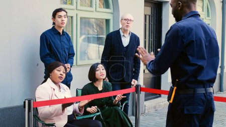 Photo for Bargain seeking clients waiting outside shopping mall entrance opening on black friday, early morning queue. Diverse crazy customers arguing with security guard to open clothing store. - Royalty Free Image