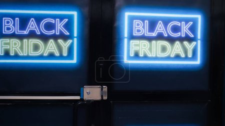 Photo for Empty clothing shop with labels for black friday event, stylish fashionable items and accessories at discounted prices. Clothing store decorated with glowing signs and banners. - Royalty Free Image
