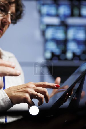 Photo for Trained technicians updating data center hardware, writing intricate binary code scripts on tablet, using programming to fortify cybersecurity in server room, close up - Royalty Free Image